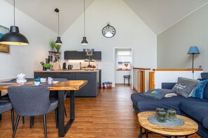Ein modernes Interieur mit Essbereich, Küche und Wohnbereich.