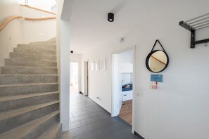 A staircase leading to a bedroom with a bed and a nightstand. - Meerhuus Carolinensiel House 2 (Carolinensiel)