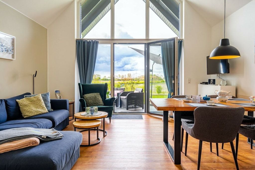 Een moderne woonkamer met een bank, salontafel en eettafel.