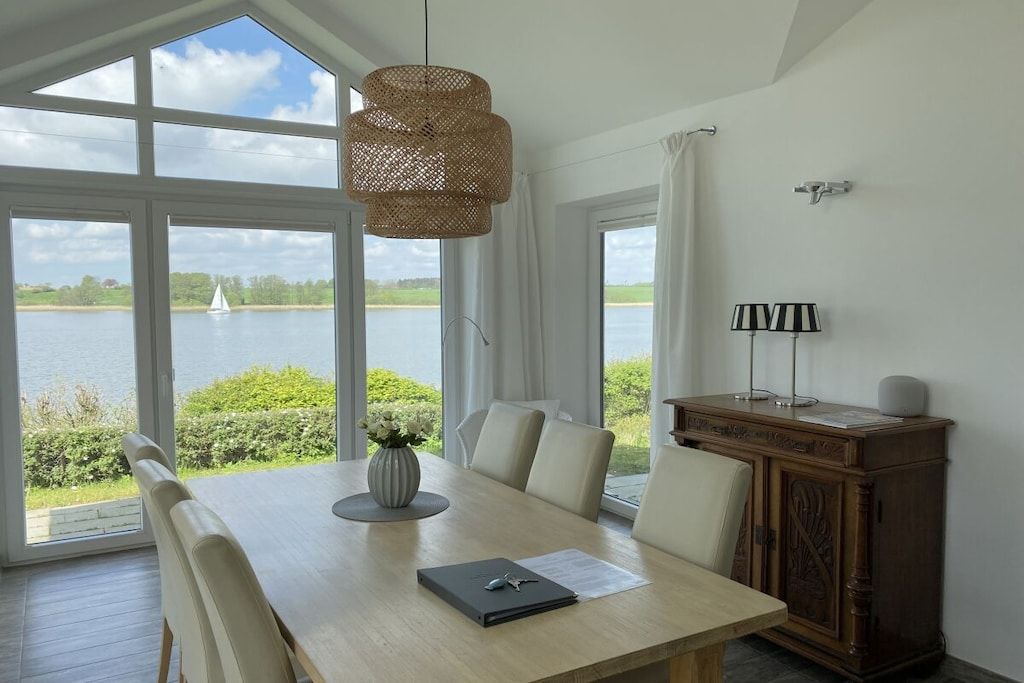 A dining area with a table, chairs, a vase, and a lamp.