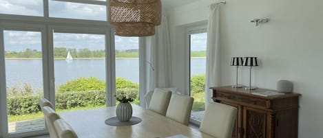 Un comedor con una mesa, sillas, un florero y una lámpara.