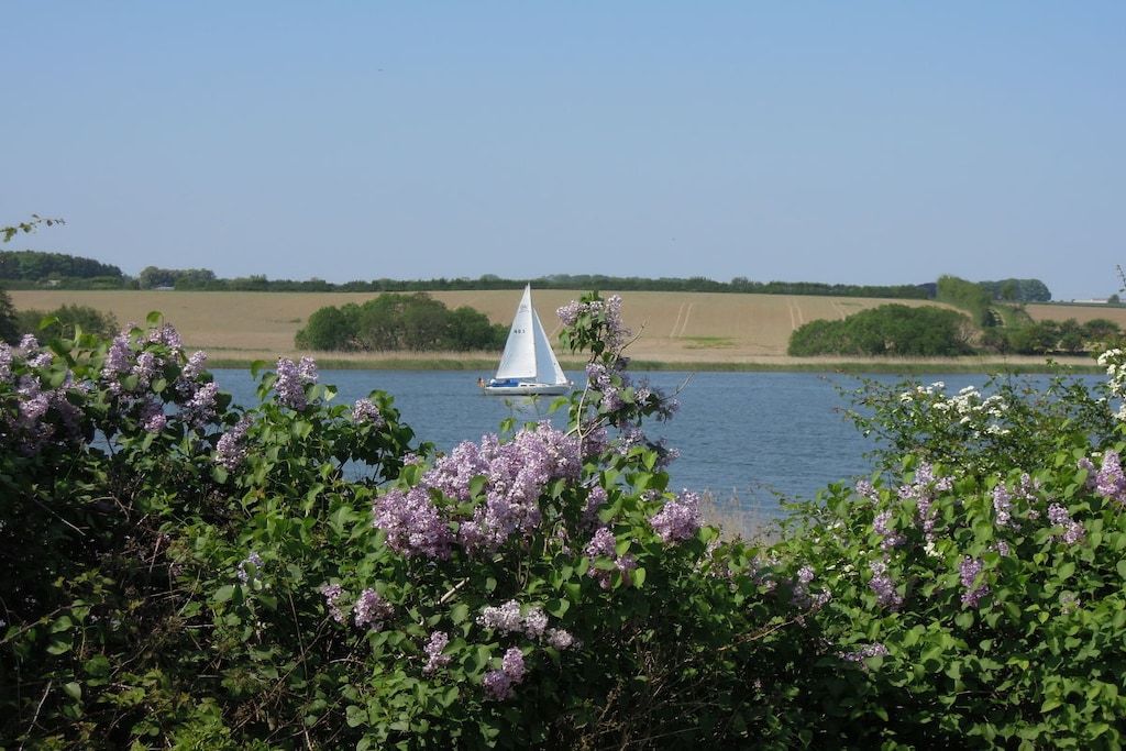 A sailboat on a calm lake with a clear sky.