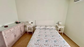 A bedroom with a bed, bedside tables, a dresser, and a mirror.