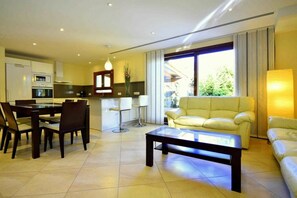 Un salon moderne comprenant un canapé, une table basse et un coin repas avec des chaises et une table.