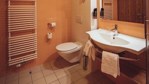A bathroom with a toilet, sink, and shower area. - Hotel Videc (Maribor)