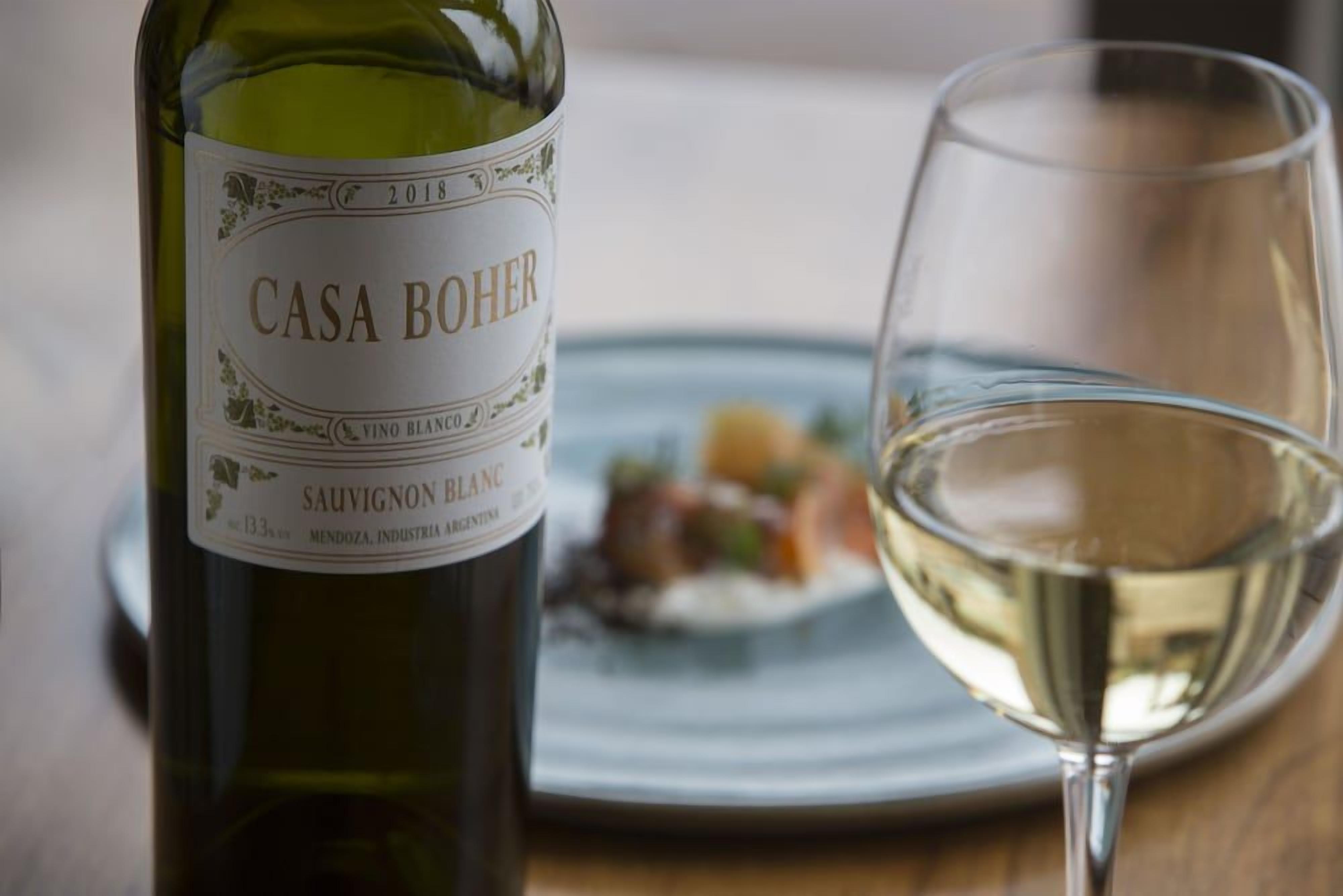 Eine Flasche Casa Boher Sauvignon Blanc und ein Weinglas auf einem Tisch.