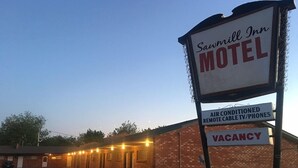 A motel sign with amenities including air conditioning, cable TV, and phones. - Sawmill Inn (Hennessey)