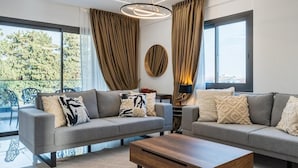A modern living room with two grey sofas, a wooden coffee table, and a large window with curtains. - Casino & Mall Jacuzzi Penthouse (Lemesos)