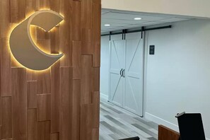 Un espace d’accueil avec un mur en bois et un luminaire en forme de croissant.