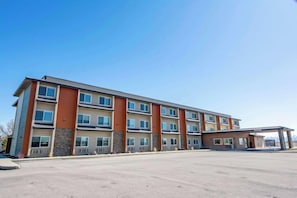 A multi-story hotel with a flat roof, large windows, and a covered entrance.