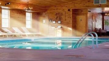 A wooden cabin with a pool area, including lounge chairs and a pool ladder.