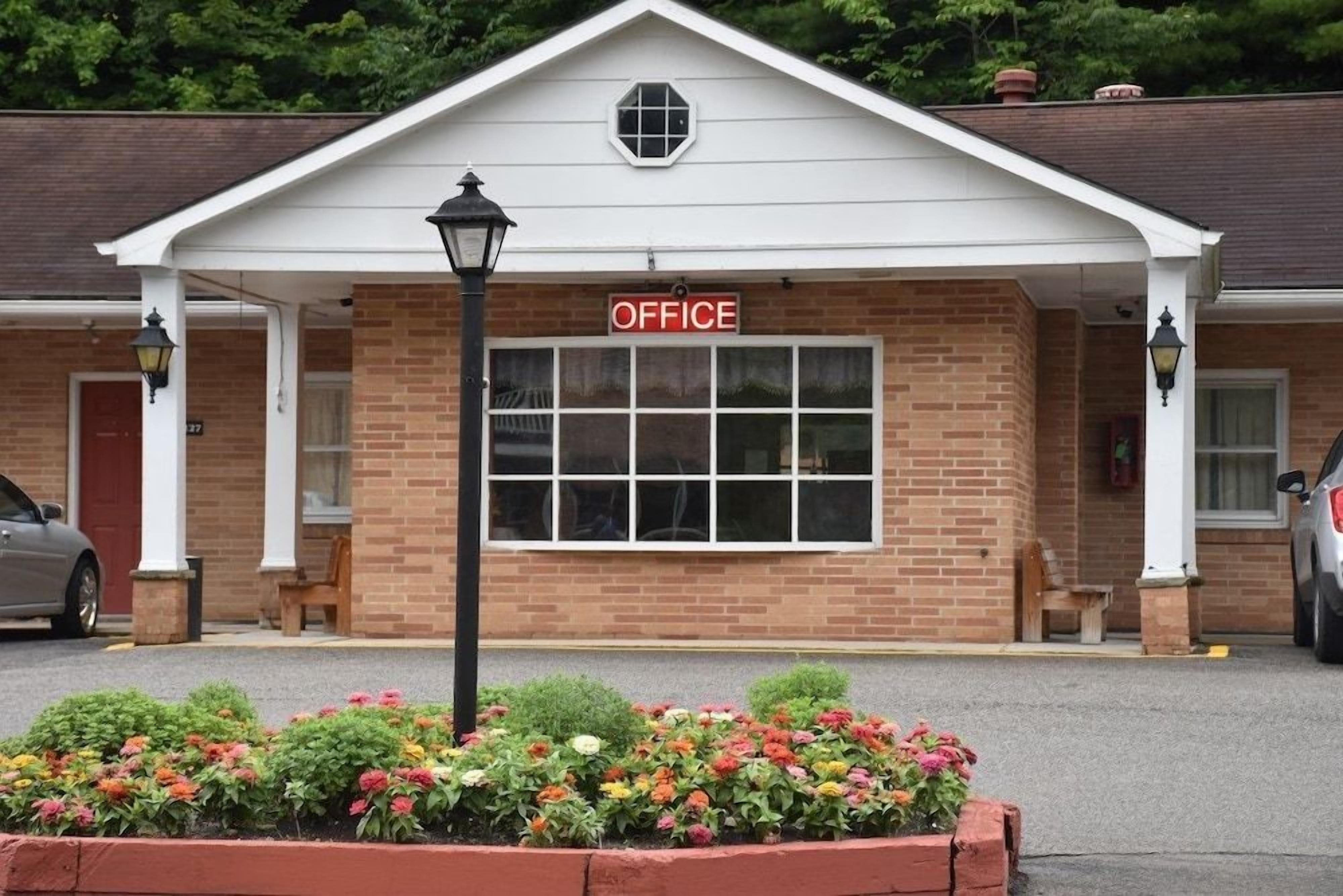 A brick building with a white facade and a sign that reads 'OFFICE'.