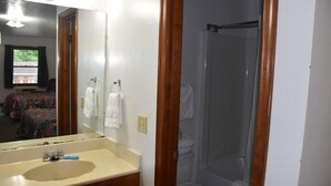Ein Badezimmer mit Waschbecken, Spiegel und Dusche.