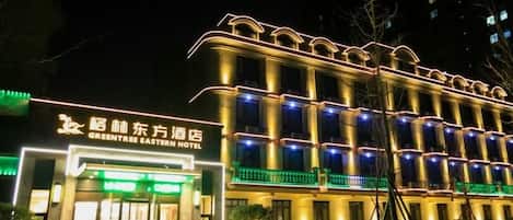 Ein Hotel im traditionellen Baustil, mit mehreren Balkonen und einer gut beleuchteten Fassade.