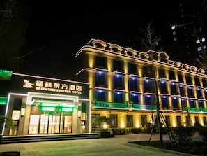Un hotel de estilo arquitectónico tradicional, con varios balcones y una fachada bien iluminada.