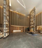 Un moderno vestíbulo con un mostrador de recepción curvo, paneles de madera verticales y suelo de mármol.