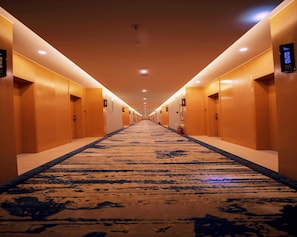 A hotel corridor with a carpeted floor, doors on both sides, and overhead lighting. - Greentree Eastern Xiangyang Zhongyuan West Road Hotel (Puyang)