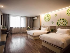 Ein Hotelzimmer mit zwei Betten, einem Schreibtisch und einem Stuhl.