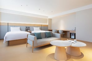 A modern hotel room with a bed, sofa, two round tables, and a small kitchenette. - Ji Hotel (Changsha)