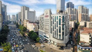 Un immeuble à plusieurs étages doté d’une façade incurvée, de grandes fenêtres et d’une enseigne indiquant qu’il s’agit d’un hôtel.