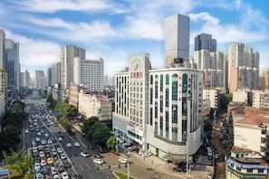 A multi-story building with a curved facade, large windows, and signage indicating a hotel. - Ji Hotel (Changsha)