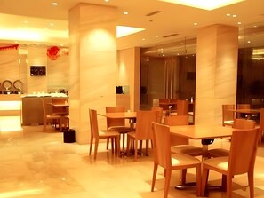 A modern dining area with marble flooring, wooden tables and chairs, and a glass partition separating the dining space from the kitchen. - Ji Hotel (Changsha)