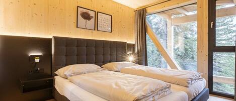 Ein Schlafzimmer mit einem großen Bett, einem Nachttisch und einem Fenster mit Vorhängen.