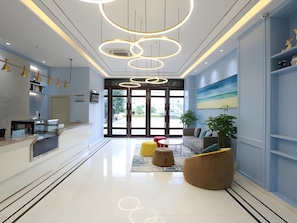 A modern reception area with a glass desk, a sofa, and a coffee table.