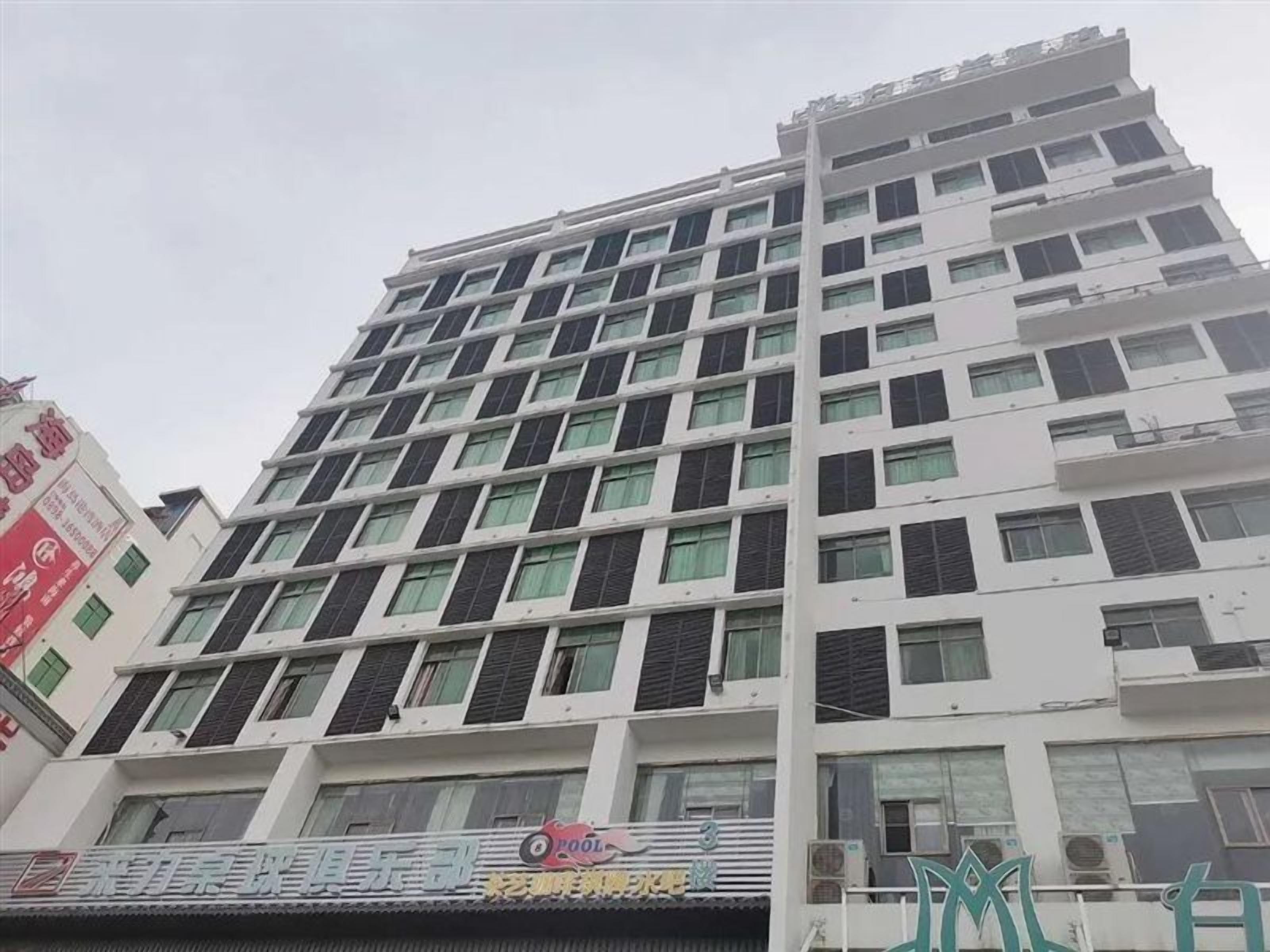 A multi-story building with a modern architectural design, featuring a series of balconies and windows.