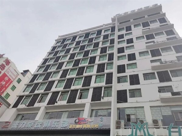 A multi-story building with a modern architectural design, featuring a series of balconies and windows. - Magnotel (Chengmai)