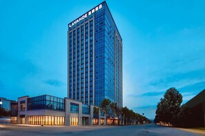 Un hôtel de grande hauteur, doté d’une façade moderne en verre et d’une enseigne bien visible au sommet.