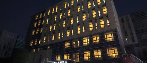 A multi-story hotel with illuminated windows and a prominent entrance.
