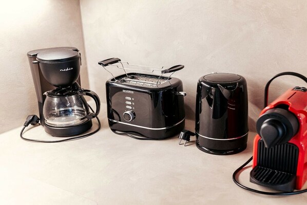 A coffee maker, a toaster, and a red vacuum cleaner on a countertop. - Cabin in Niederwölz with sauna (Niederwölz)