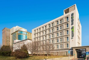 Un hôtel à plusieurs étages, doté d’une façade moderne, de grandes fenêtres et d’une entrée imposante.