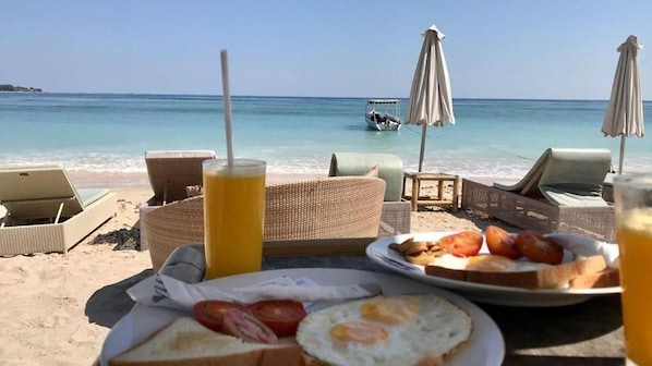 Desayuno frente al mar con vista al océano, e incluye un barco a lo lejos.