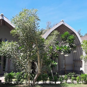 Un edificio con techo curvo y un jardín con diversas plantas.