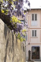 Un edificio con un letrero que dice 'LE CANNELLE' y una pared de piedra en primer plano.