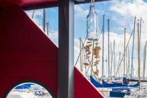 A marina with multiple boats docked, a clear sky, and a red structure in the foreground.