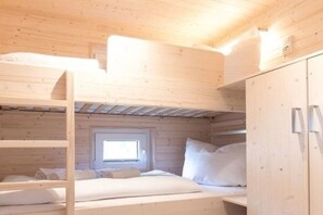 A bunk bed room with a window, wooden walls, and a wardrobe. - Houseboat Kaddi's Sunflower - House & Sea (Fehmarn OT Burgstaaken)