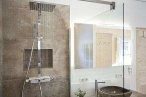 A modern bathroom with a glass-enclosed shower, a large mirror, and a stone sink. - Cabin in Murau with sauna and terrace (Murau)