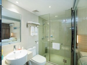 A modern bathroom with a glass-enclosed shower, a white sink, and a toilet. - City Comfort Inn Wuhan Xudong (Wuhan)