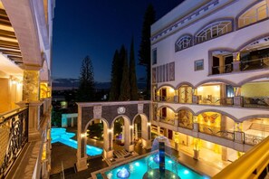 A multi-story hotel with a swimming pool, outdoor lighting, and a view of the surrounding landscape. - Hotel and Spa Mansion Solis by Hotsson (Morelia)