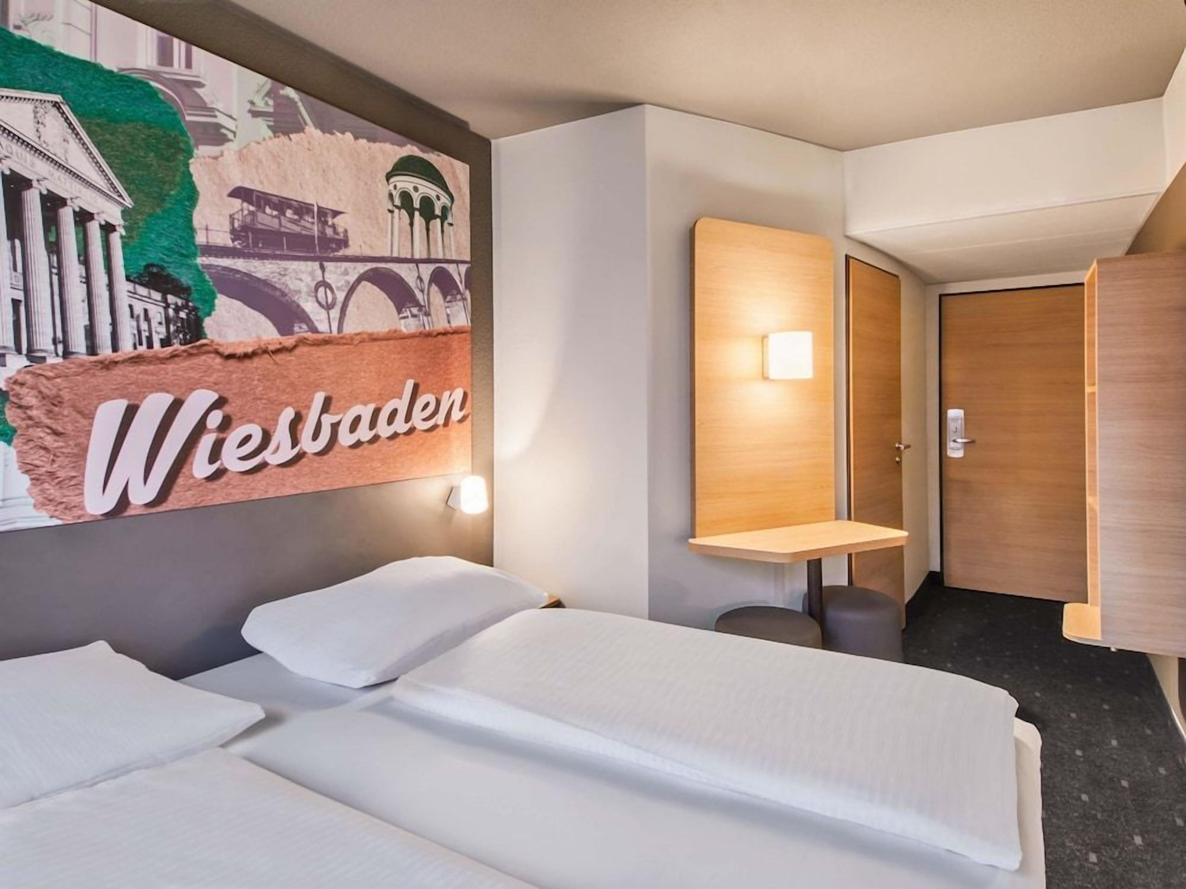 Ein Hotelzimmer mit einem Bett, einer Wandleuchte und einer Tür.