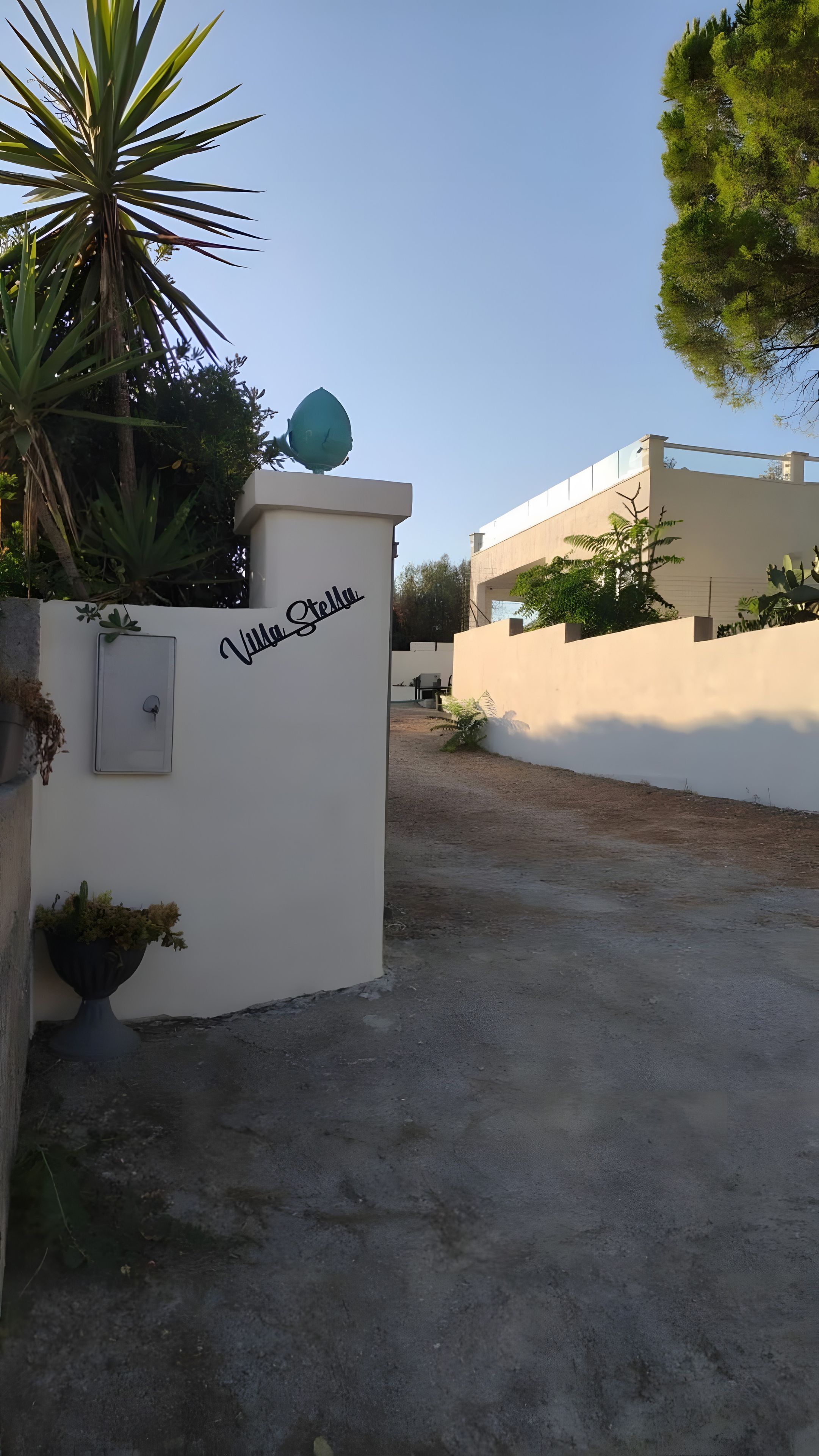 En port med indgang, et skilt der viser 'Villa Stella' og en parabolantenne øverst.