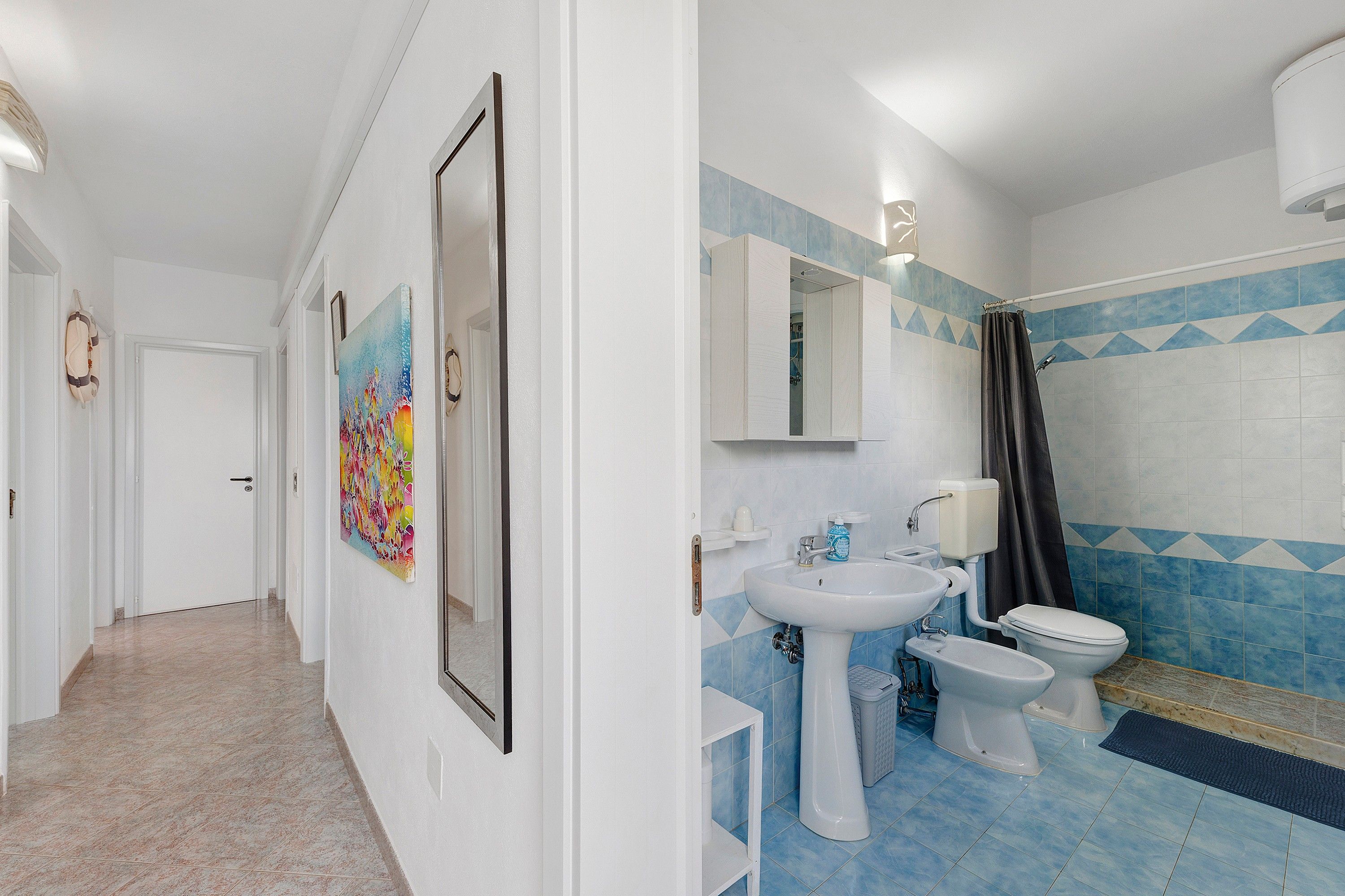 Een badkamer met een wastafel, toilet en douchecabine.
