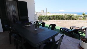 A patio with a table and chairs, a potted plant, and a view of the sea. - Villa 'Stella' with Sea View, Wi-Fi and Air Conditioning (Torre Vado)
