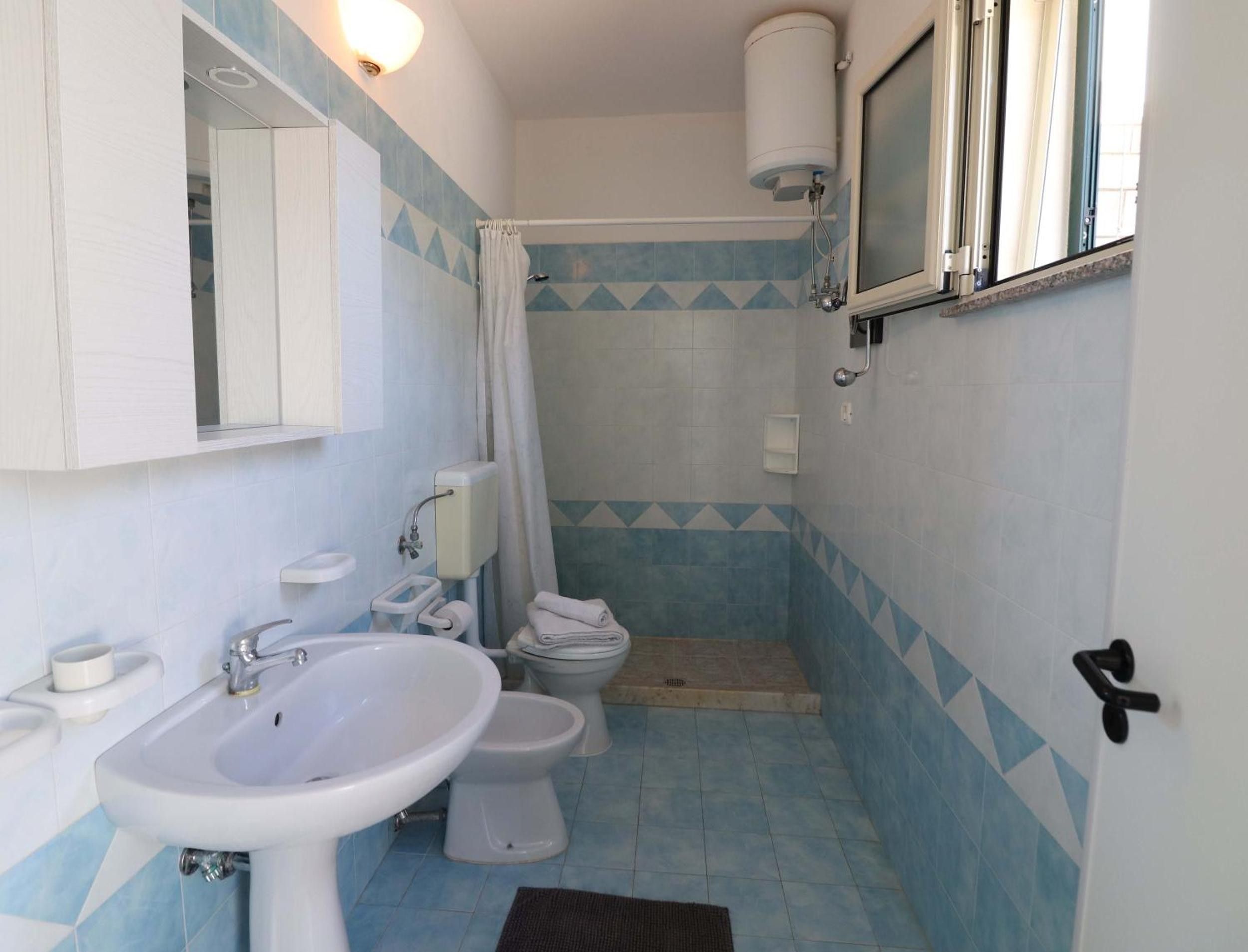 A bathroom with a sink, toilet, and shower.