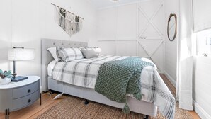 Une chambre à coucher comprenant un lit, une table de chevet, une lampe et des éléments de décoration murale.