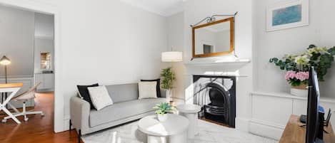 Un salon moderne avec une cheminée, un canapé, une table basse et un coin repas avec une chaise.