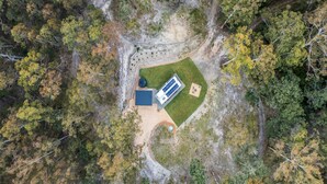 A rectangular building with a flat roof, surrounded by a fenced area with a paved path leading to it. - Mijo | The Nook-Off grid Rural Retreat (Tenterfield)